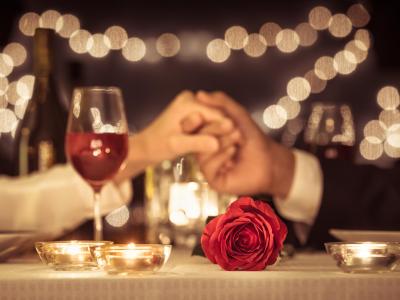 Cena romantica a lume di candela con rose e vino.