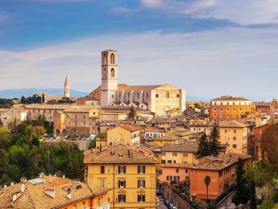 Vista panoramica di Perugia con edifici storici e paesaggio collinare.