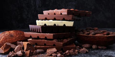 Barrette di cioccolato impilate con fave di cacao.