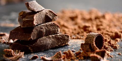 Pezzi di cioccolato su un tavolo con cacao.