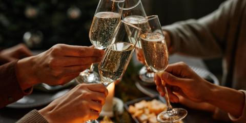 Persone brindano con calici di champagne durante una festa.