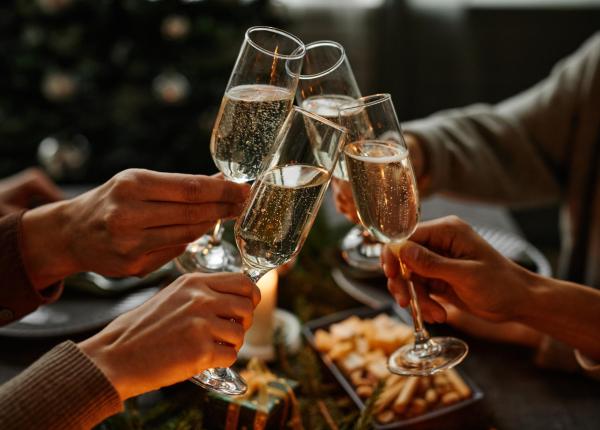 Persone brindano con calici di champagne durante una festa.