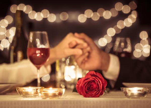 Cena romantica a lume di candela con rose e vino.