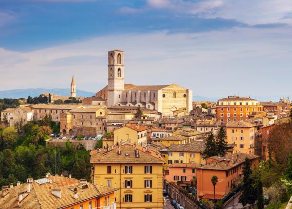 Vista panoramica di Perugia con edifici storici e paesaggio collinare.