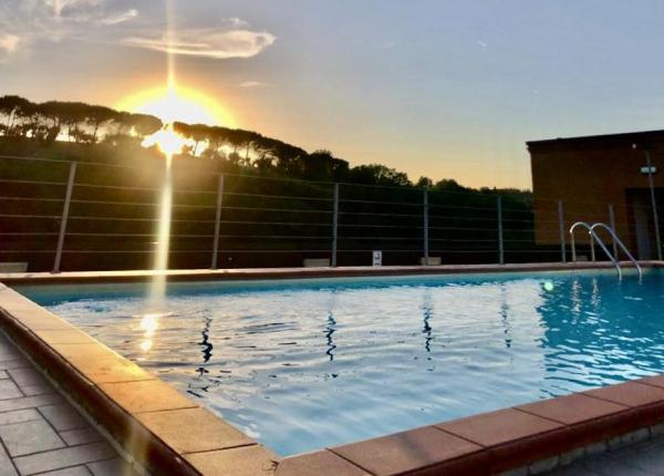 Pool at sunset with a view of trees.