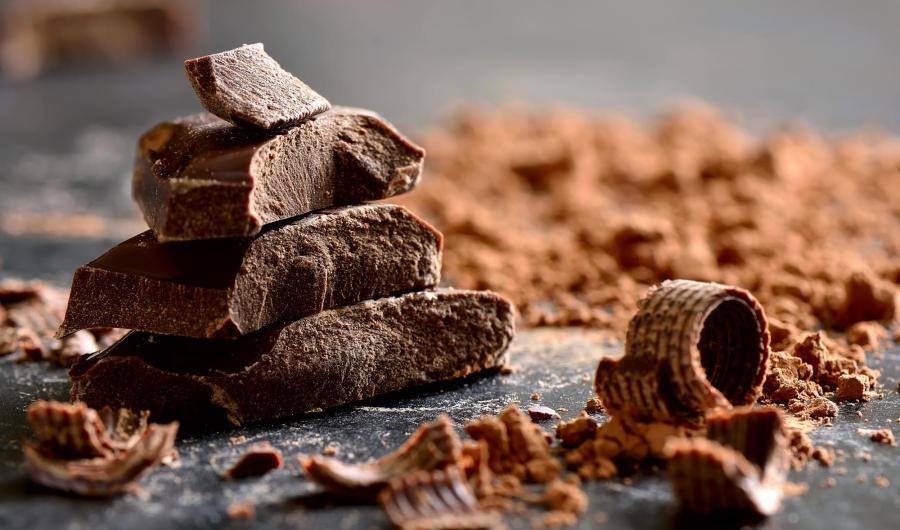 Pezzi di cioccolato su un tavolo con cacao.