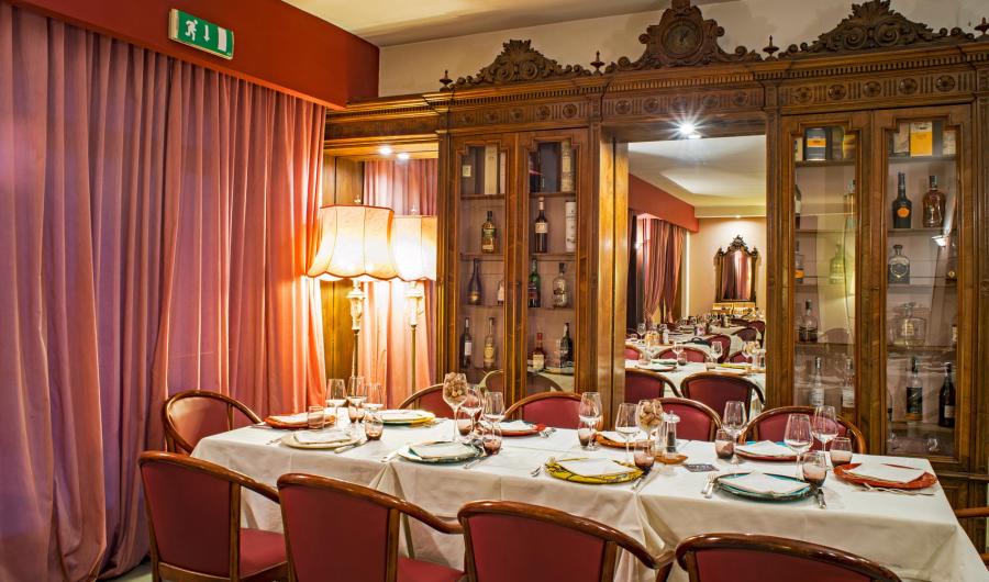 Elegante sala da pranzo con arredi classici e illuminazione calda.