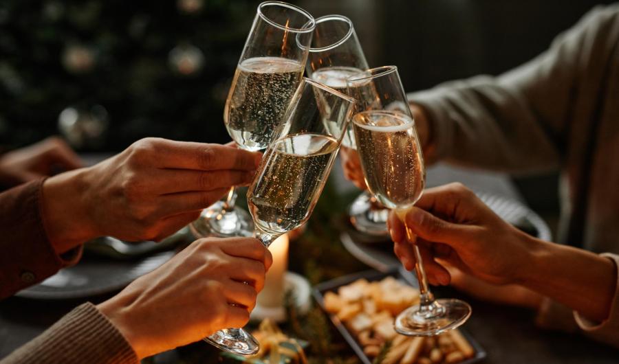 Persone brindano con calici di champagne durante una festa.